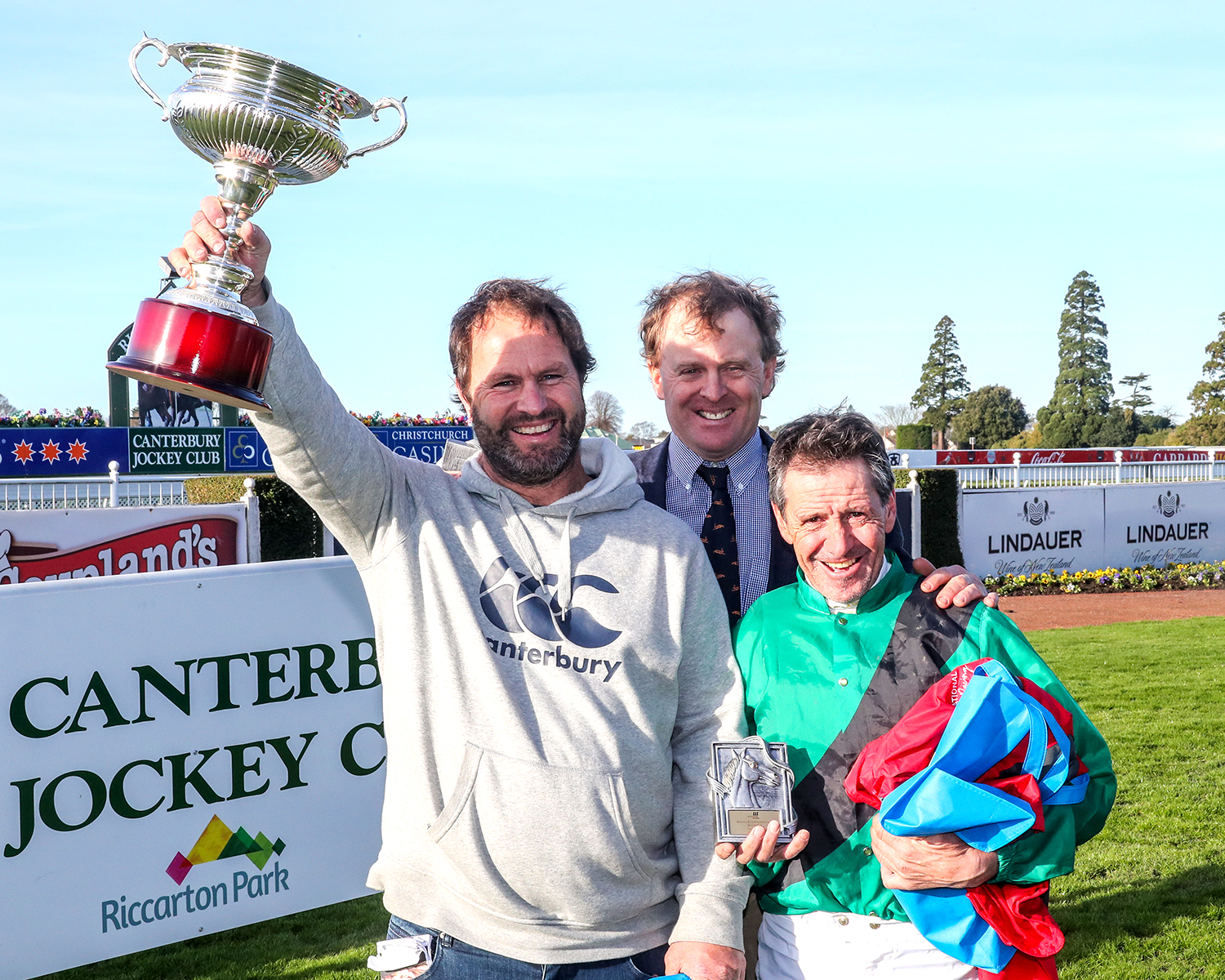 Part-owner Paul Mitchell celebrates with jockey Chris Johnson and trainer Simon Wilson (rear) after winning the Gr.3 Winning Edge Presentations 122nd Winter Cup with Dez Photo credit: Race Images South